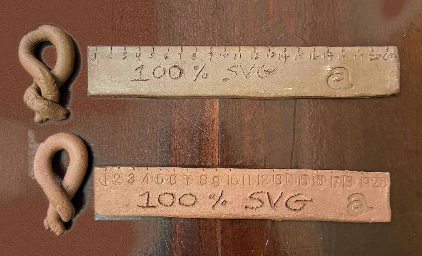 Two clay rulers stamped 100% SVG beside twisted clay knots